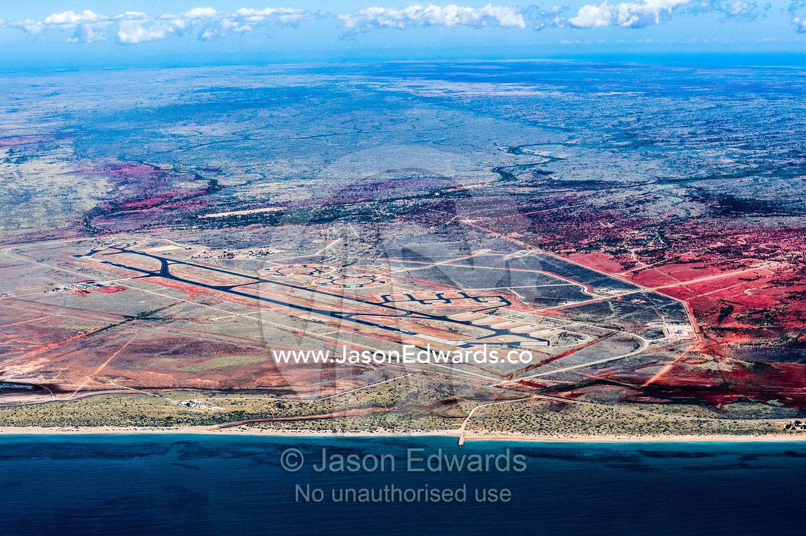 An aerial view of an airport and runway tarmac in a coastal desert. Exmouth, Ningaloo Reef, Western Australia, Australia.