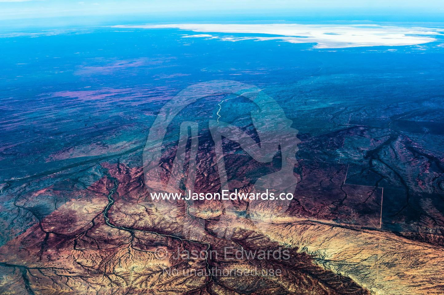 Ancient riverbeds wind their way through rugged desert mountains. Exmouth, Ningaloo Reef, Western Australia, Australia.