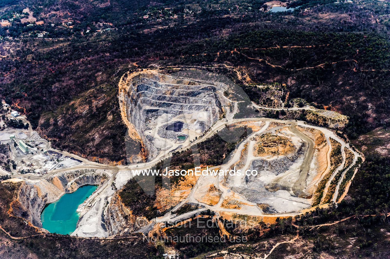Aerial view of an open-cut mine and denuded forest on nearby hills. Perth, Western Australia, Australia.