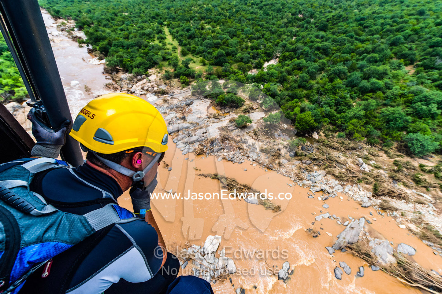 Police and airforce crew search for trapped survivors in flood waters. Kruger National Park, South Africa.