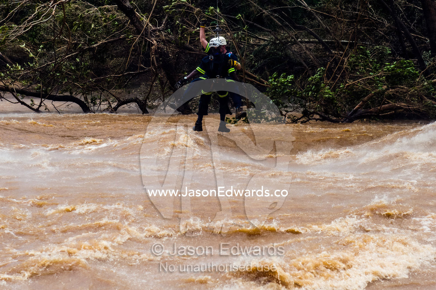 An Airforce and police rescue crew lowered onto a flooded river. Kruger National Park, South Africa.