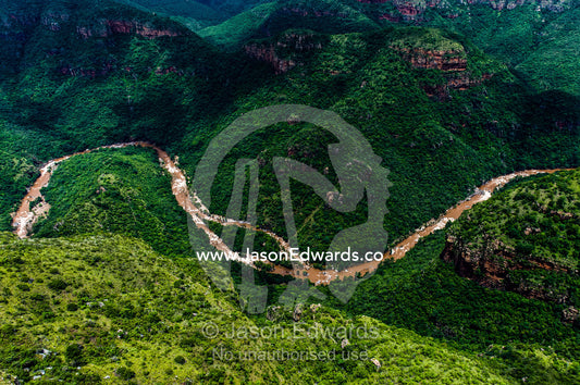A flooded river full of soil and silt carves its way through a gorge. Blyde River Canyon, South Africa.