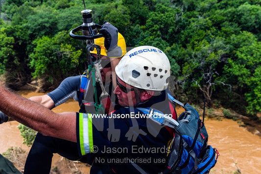 Airforce and police rescue team descend on a winch to a flooded river. Kruger National Park, South Africa.