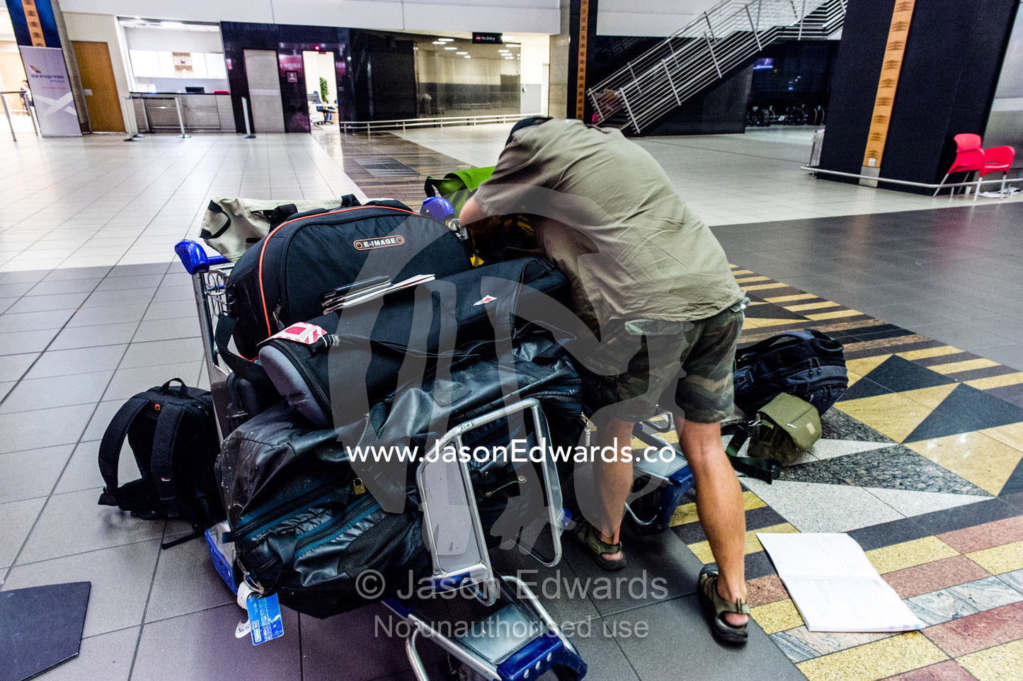 A dejected man waits with his luggage after missing the last flight. Cape Town, Western Cape, South Africa.