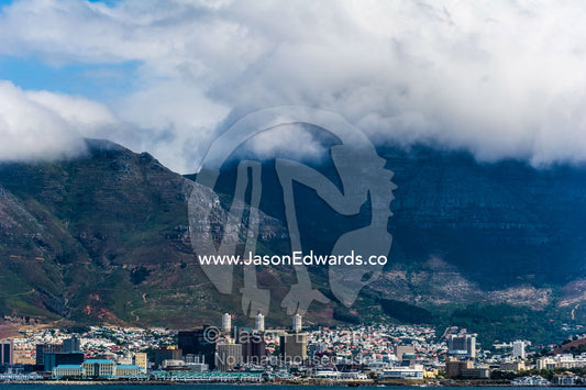 Cape Town in the cloud covered shadow of Table Mountain. Table Mountain, Cape Town, Cape Peninsula, Western Cape, South Africa.