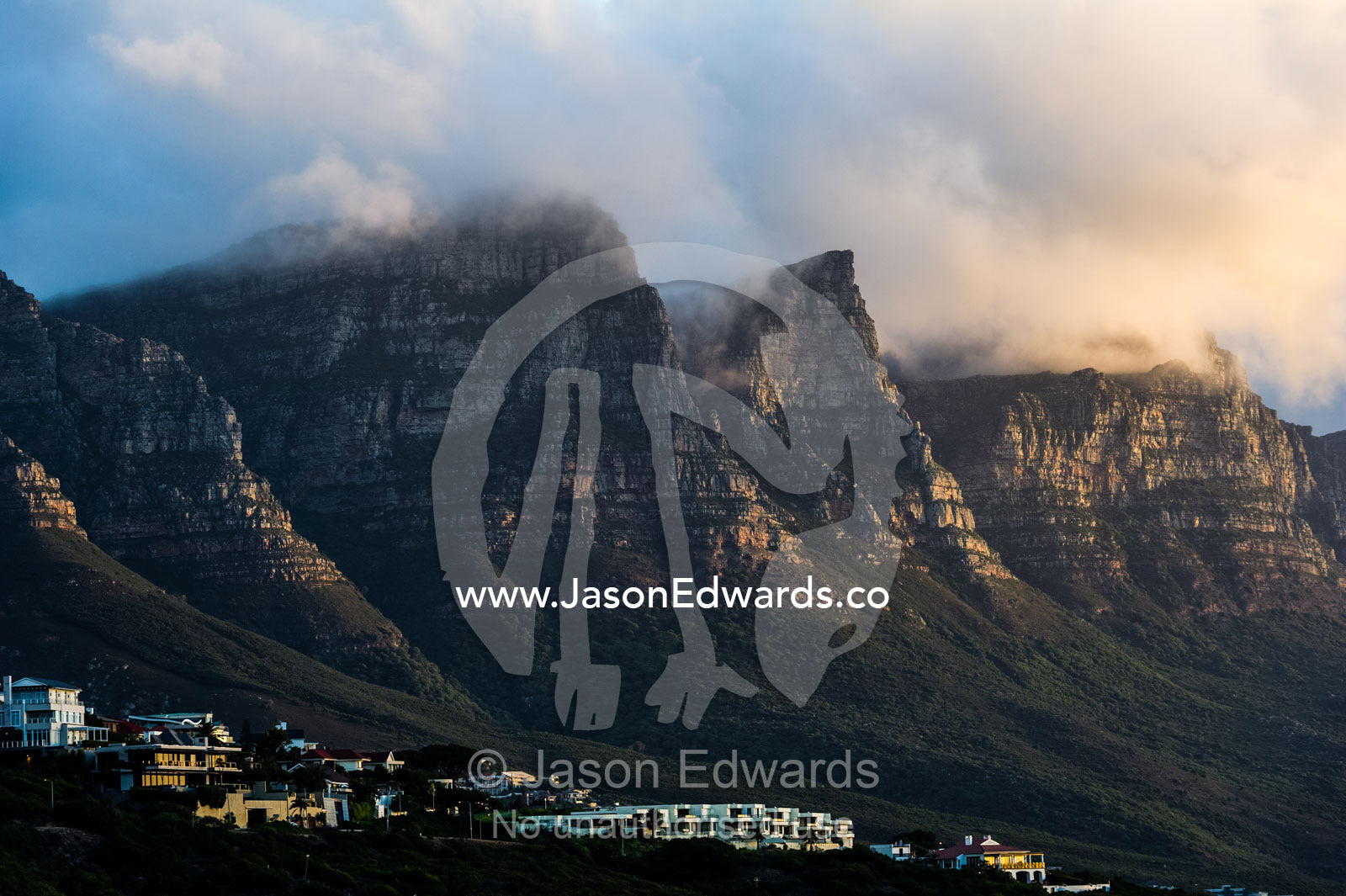 Suburban development on the slopes of a rugged coastal mountain range. The Twelve Apostles, Chapmans Peak Mountain Range, Cape Town, Western Cape, South Africa.