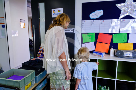 A boy shows his mother is personal locker on his first day of school. Melbourne, Carlton North, Melbourne, Victoria, Australia.