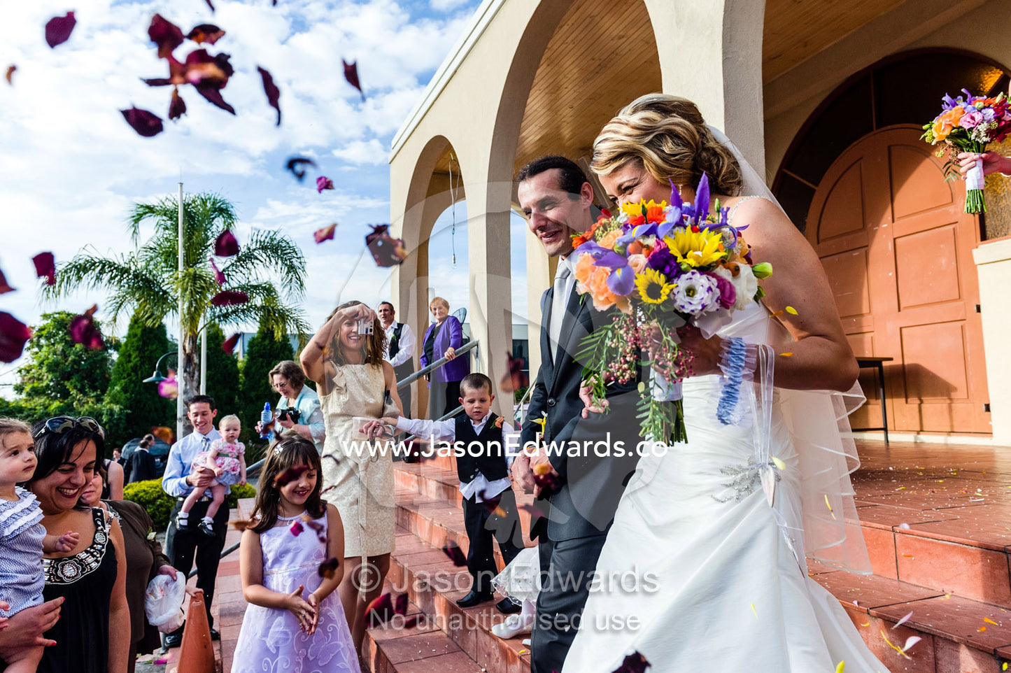 Confetti and rose petal shower a bride and groom at a Greek wedding. Melbourne, Victoria, Australia.
