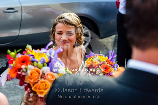 A happy, blushing bride with her bouquet at a Greek Orthodox wedding. Melbourne, Victoria, Australia.