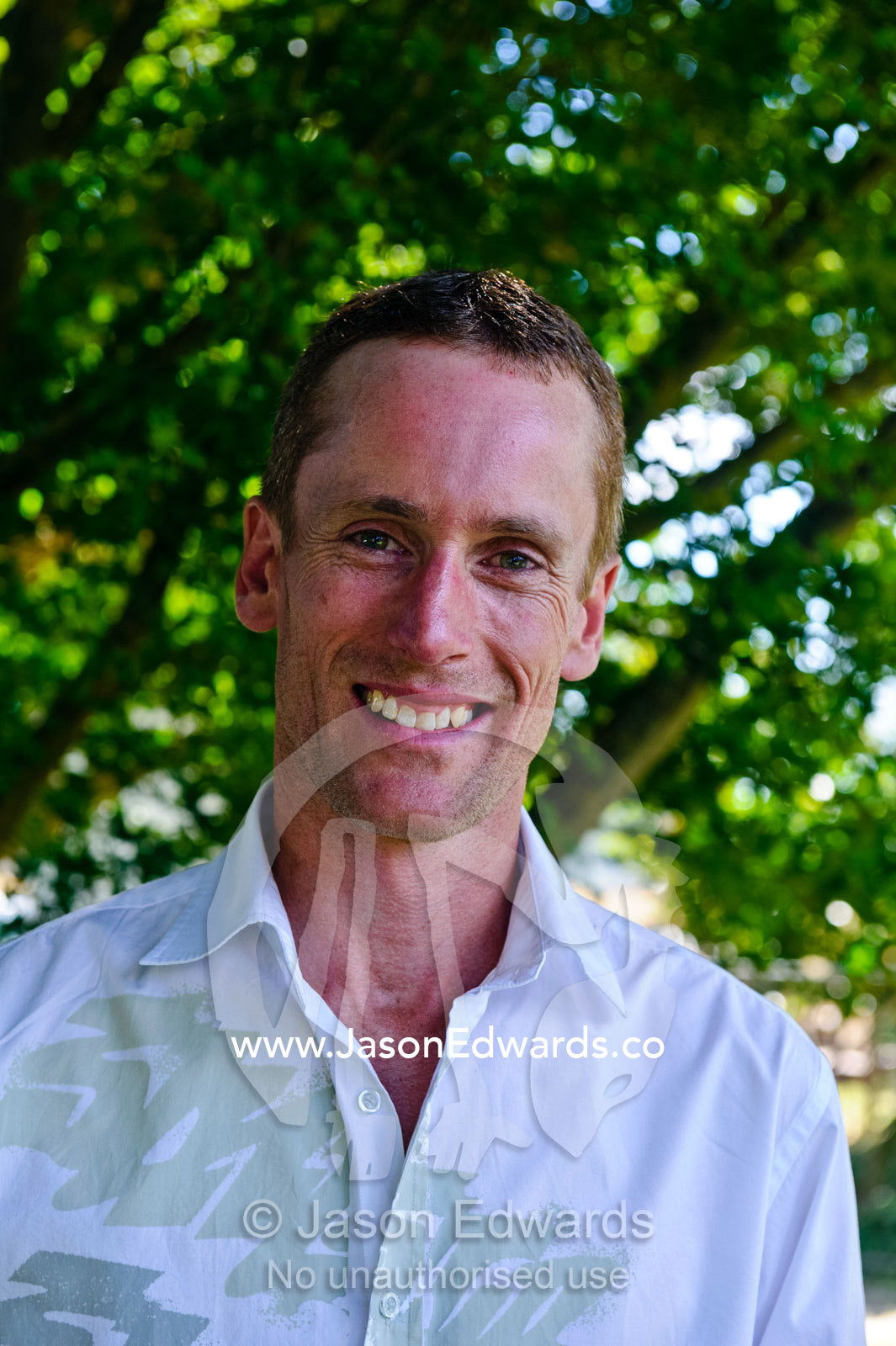 A man smiles whilst waiting for his bride at a country wedding. Alexandra, Victoria, Australia.