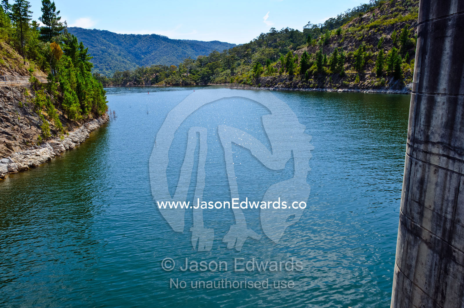 A city water catchment dam wall and spillway gates filled with water. Lake Eildon, Eildon Weir Spillway, Victoria, Australia.