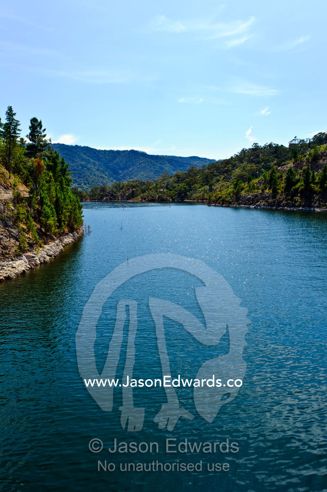 A manmade dam filled to capacity with water to supply a nearby city. Lake Eildon , Eildon Weir Spillway , Victoria , Australia