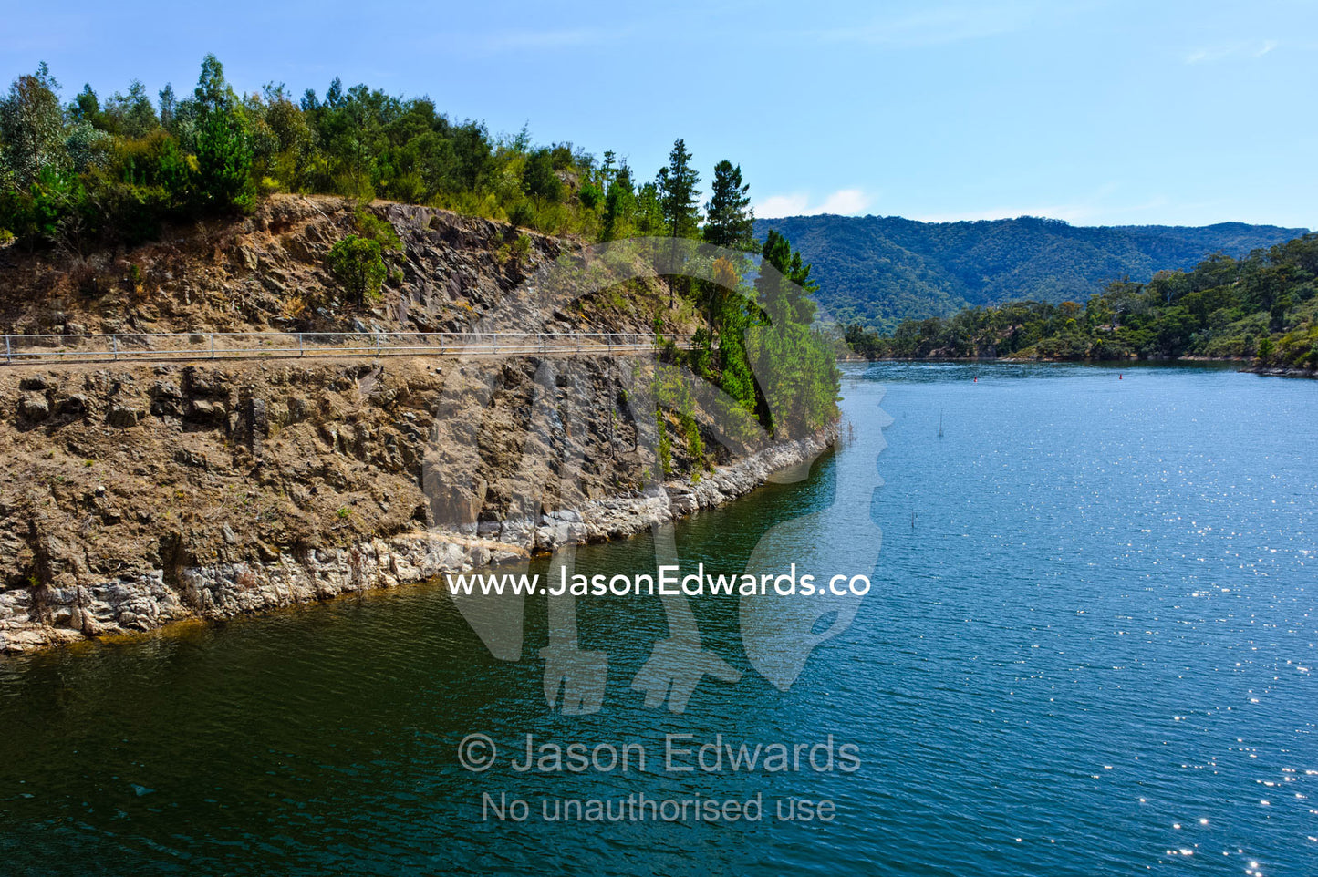 A manmade dam filled to capacity with water to supply a nearby city. Lake Eildon, Eildon Weir Spillway, Victoria, Australia.