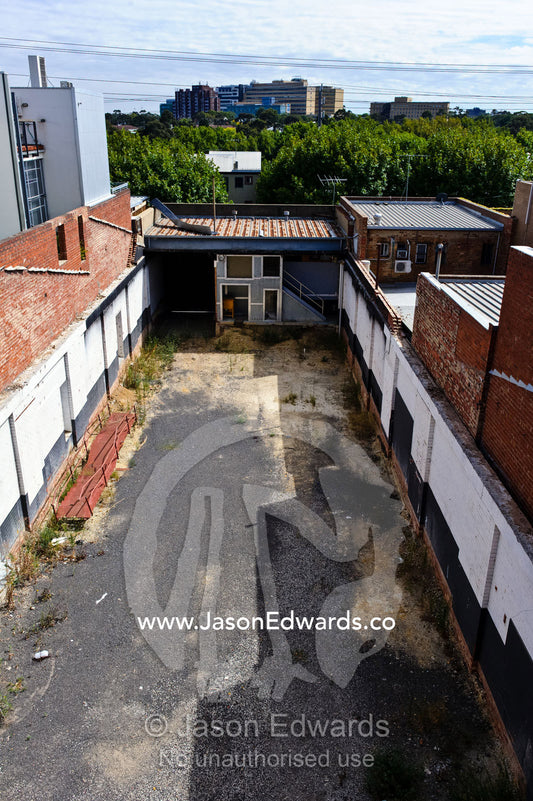 An abandoned block of land between warehouses in an inner city suburb. North Melbourne, Melbourne, Victoria, Australia.