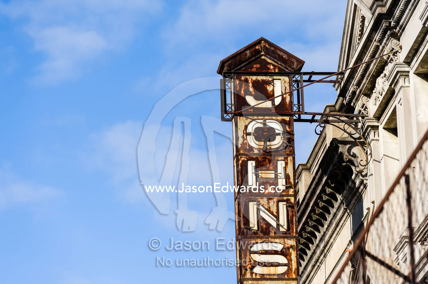 An old rusting sign hangs from the facade of a Victorian building. Collingwood, Melbourne, Victoria, Australia.