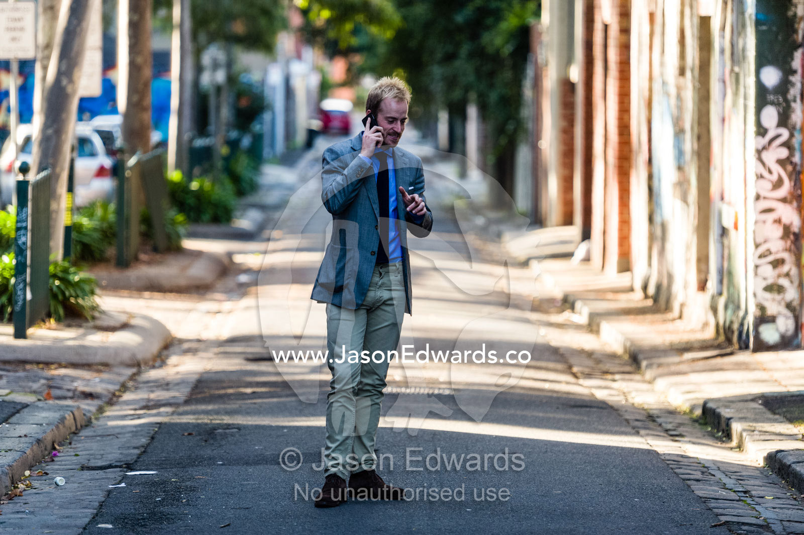 A real estate agent conducting a business meeting on a smart phone. Collingwood, Melbourne, Victoria, Australia.