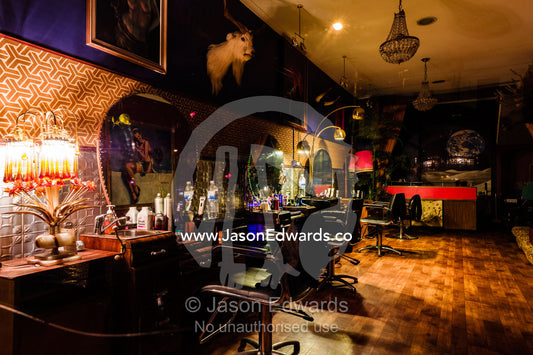 A goats head hangs over barber stools in an inner city hairdressers. Collingwood, Melbourne, Victoria, Australia.