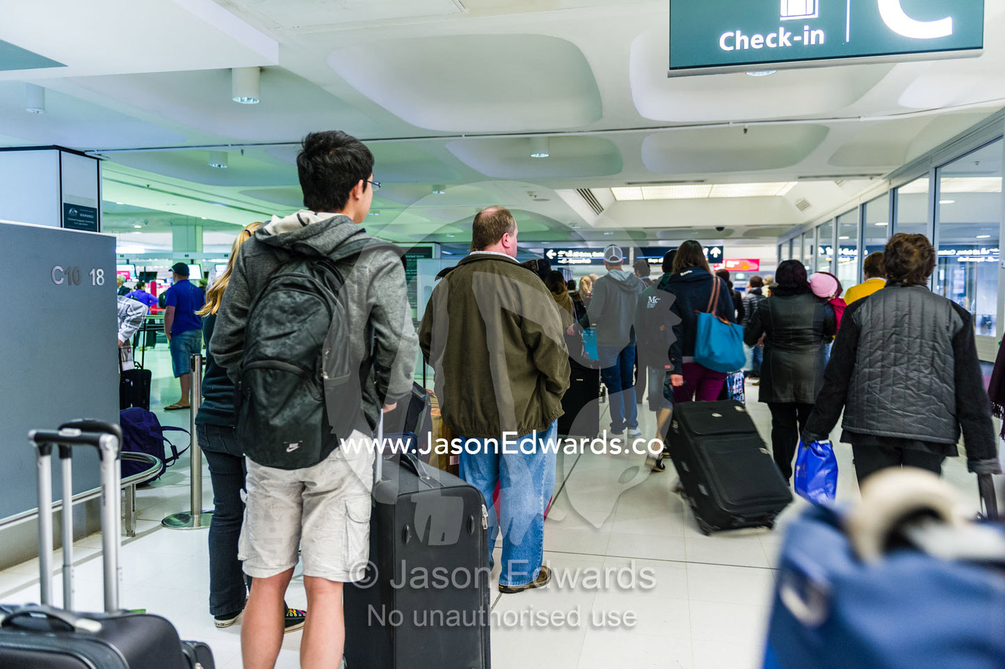 Passengers queue in an airport whilst their flight is delayed. Sydney International Airport, Sydney, New South Wales, Australia.