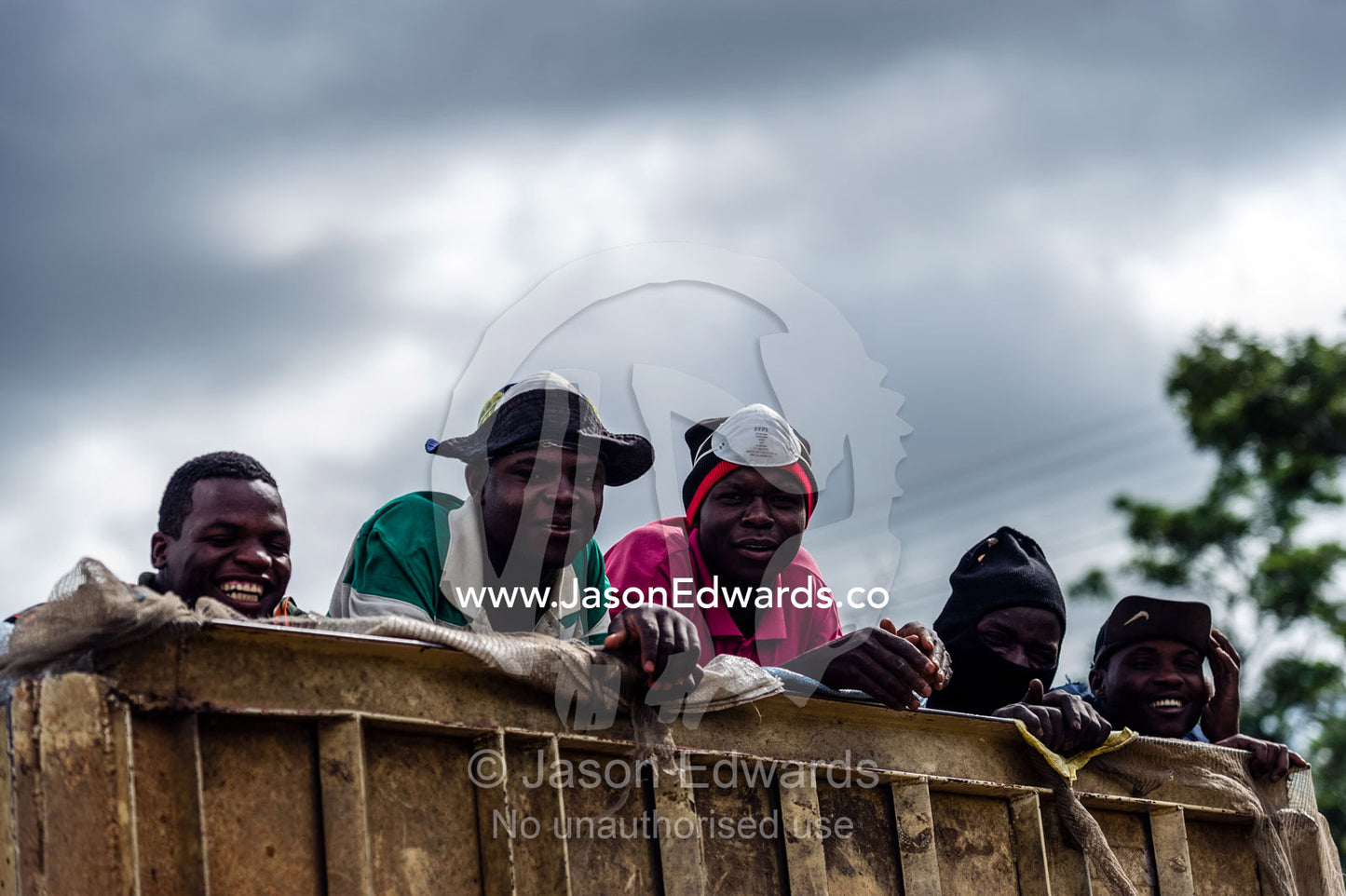 Laborers travel in the back of a truck on their way to the next job. Route 101, Naboomspruit, Modimole, Limpopo, South Africa.