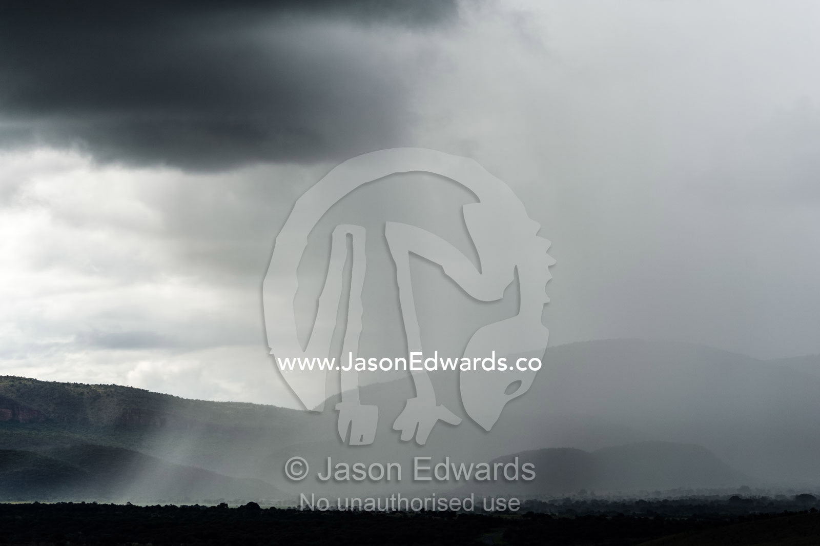 A torrential rainstorm shrouds rolling hills and farmland in grey. Route 101, Naboomspruit, Modimole, Limpopo, South Africa.