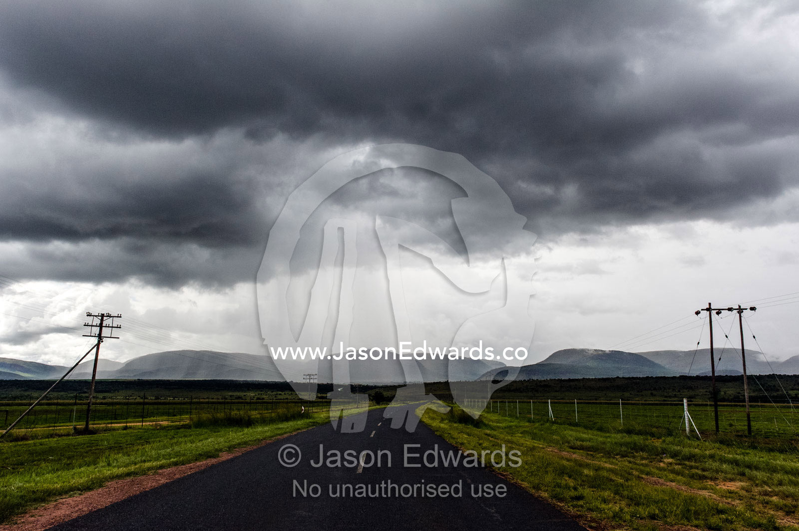 A torrential rainstorm descends on a remote country road and farmland. Route 101, Naboomspruit, Modimole, Limpopo, South Africa.