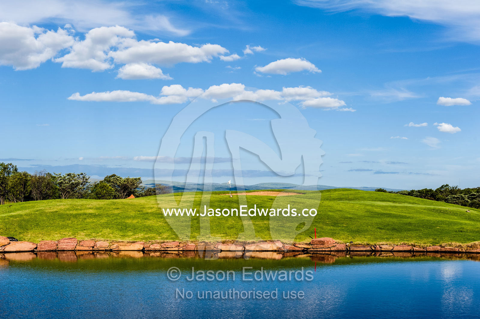 Morning view of a golf fairway and putting green beside a water trap. Legend Golf Safari Resort, Waterberg Mountains, Entabeni Game Reserve, Limpopo Province, South Africa.