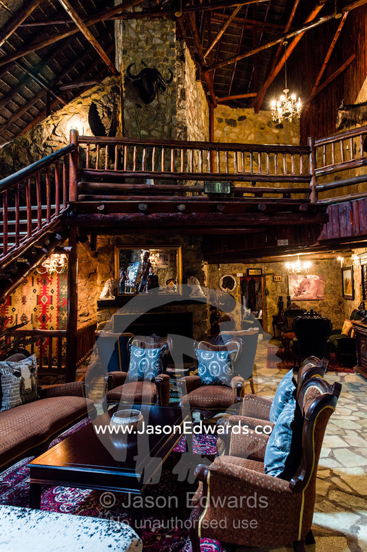 A elegant stone and timber balcony above a sitting room in a lodge. The Farm Inn, Pretoria, Gauteng Province, South Africa.