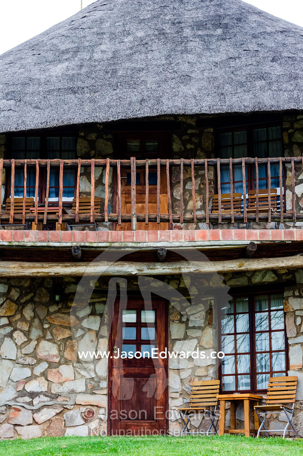 A stone guest bungalow with thatched roof in an African safari lodge. The Farm Inn, Pretoria, Gauteng Province, South Africa.
