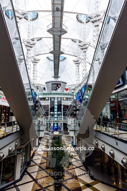 Enormous escalators connect levels in a sunlit shopping mall. Menlyn Park, Pretoria, Menlyn Mall, Pretoria, Gauteng Province, South Africa.
