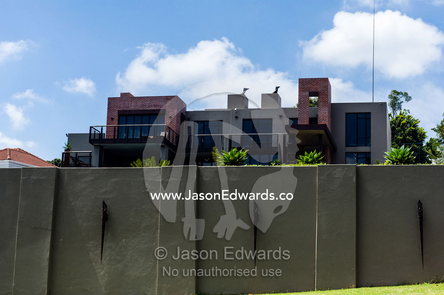 A high security wall protects a large home in an affluent suburb. Waterkloof, Pretoria, Gauteng Province, South Africa.