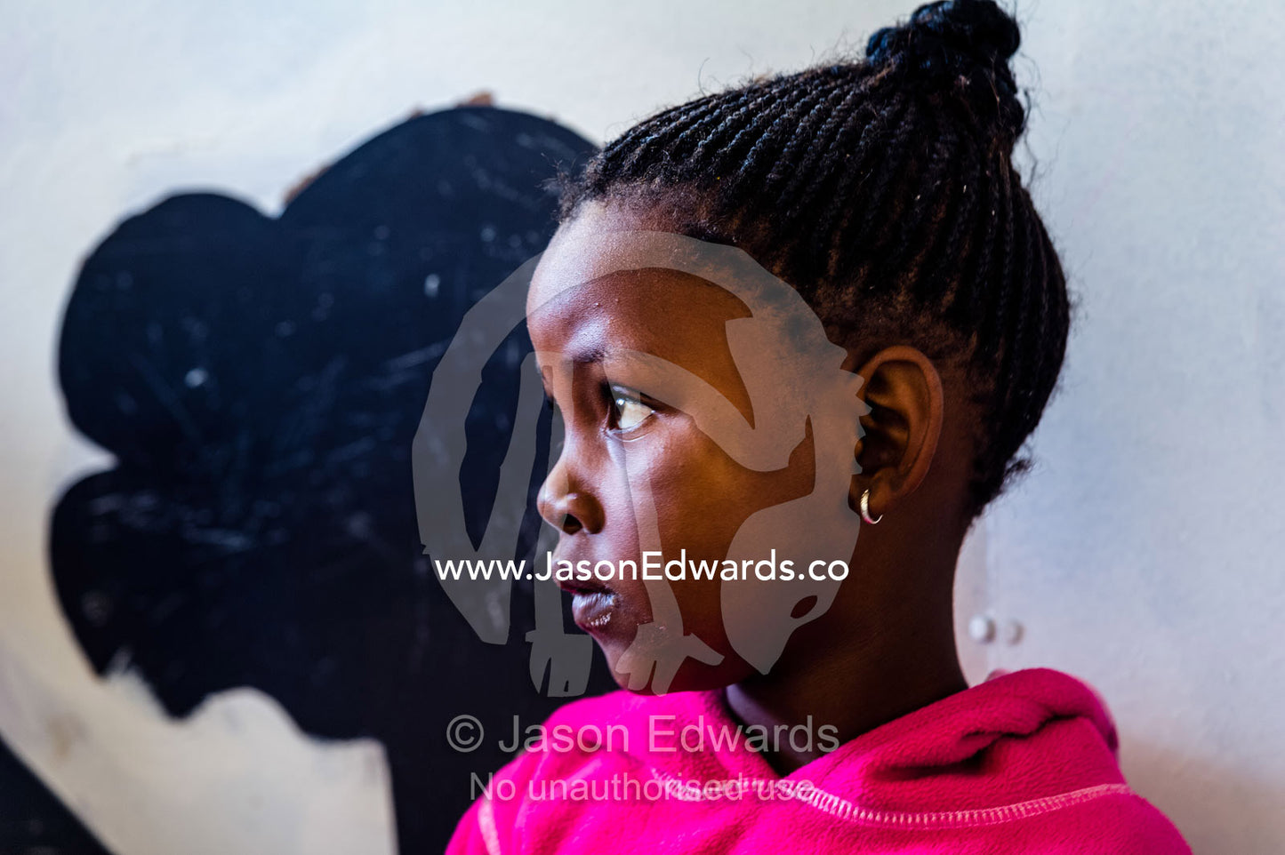 A student intensely listens to her teacher work on the alphabet. Red Hill Township and Pre-School, Cape Town, Western Cape, South Africa.