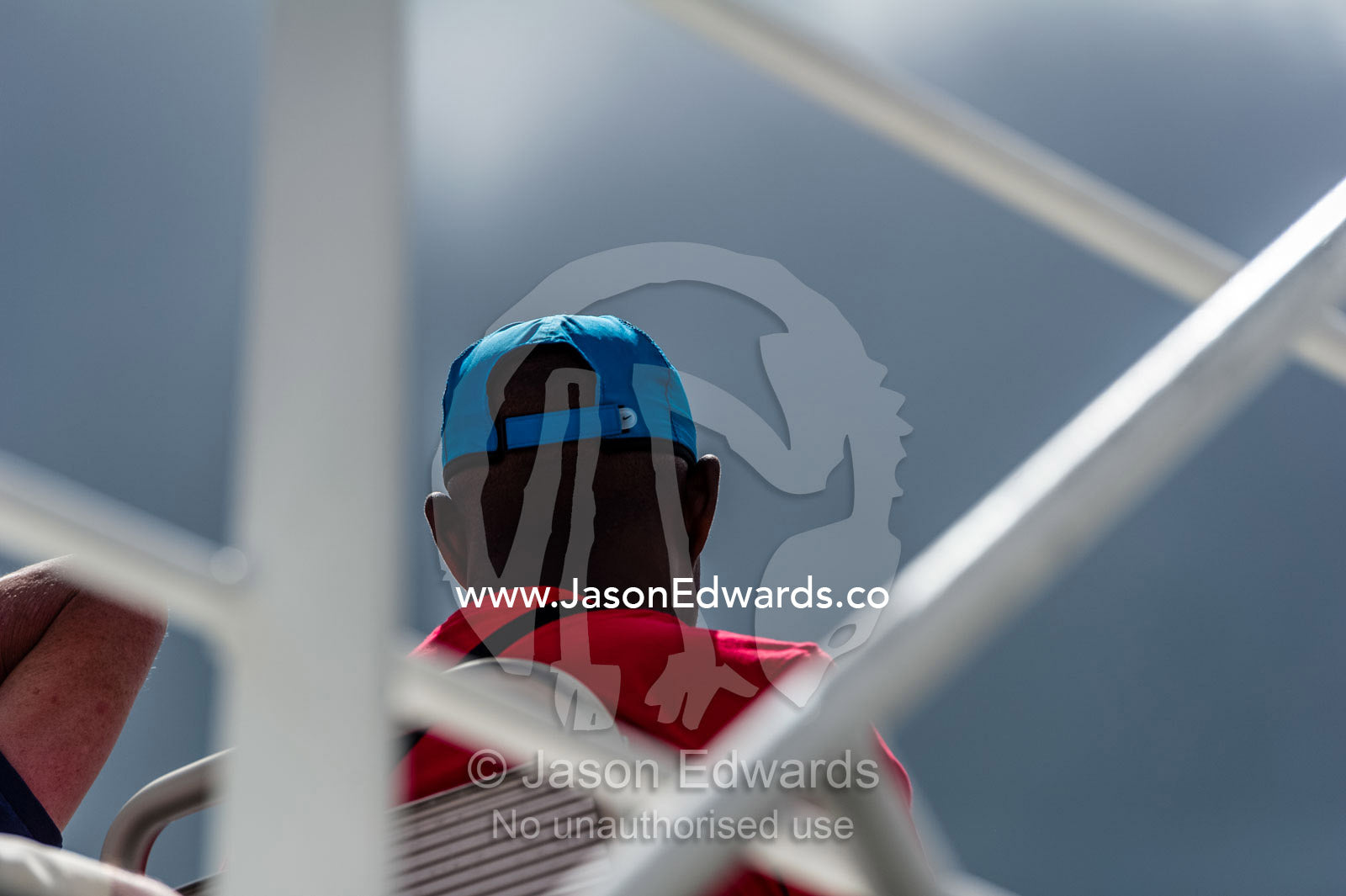 A passenger sitting on a ferry rooftop deck heading to an island. Robben Island, Cape Town, Bloubergstrand, Table Bay, Western Cape, South Africa.