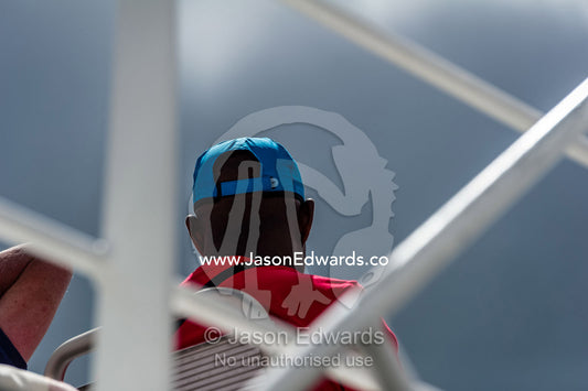A passenger sitting on a ferry rooftop deck heading to an island. Robben Island, Cape Town, Bloubergstrand, Table Bay, Western Cape, South Africa.
