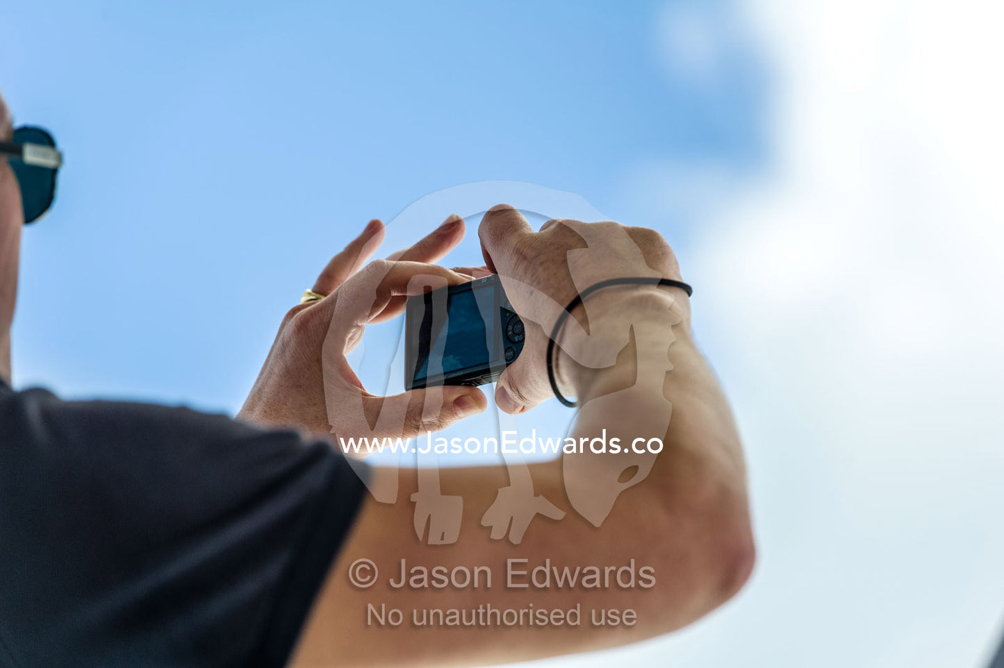 A passenger captures a photo from the deck of a ferry out at sea. Robben Island, Cape Town, Bloubergstrand, Table Bay, Western Cape, South Africa.