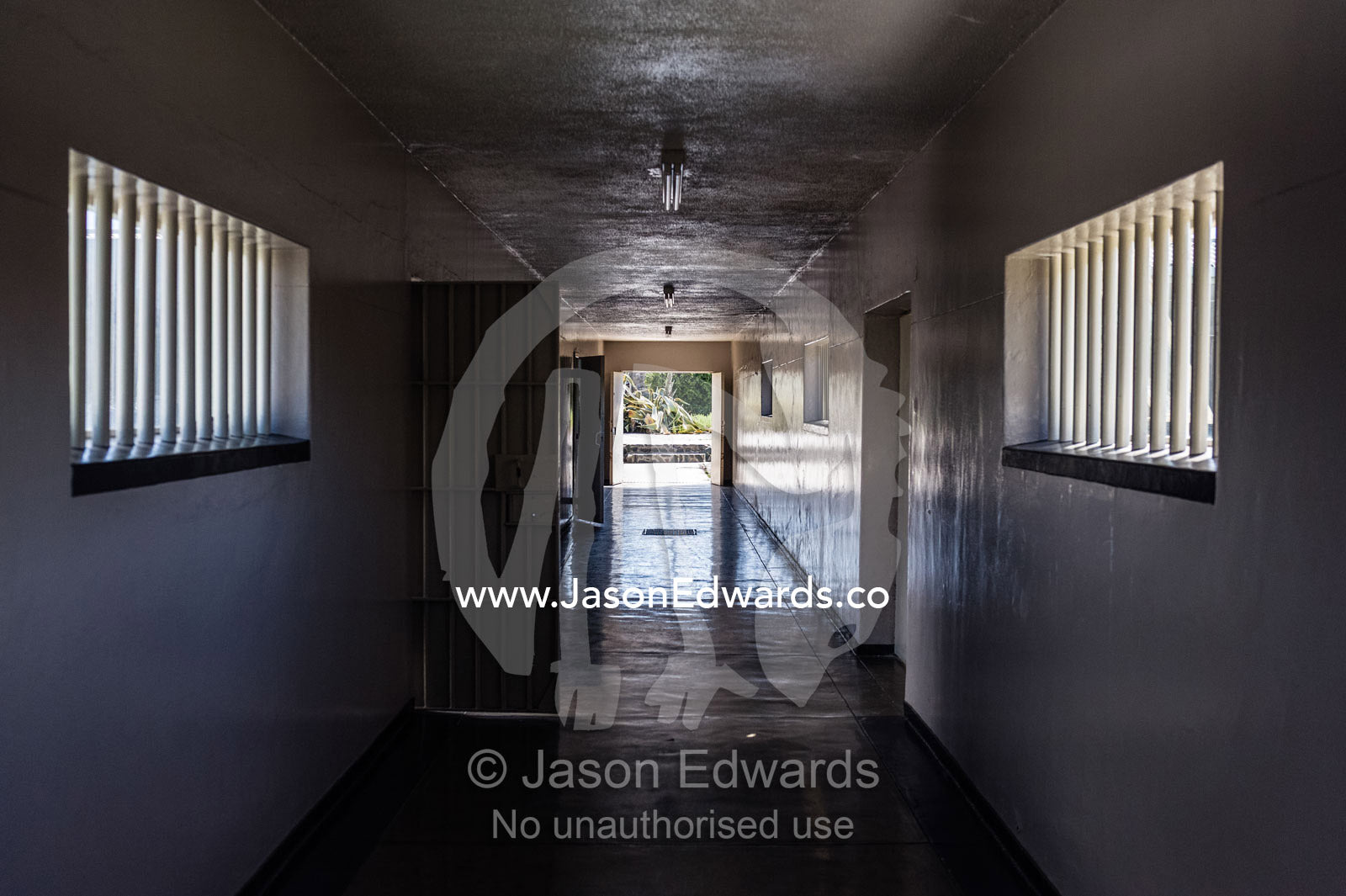 Austere prison corridor with polished concrete floor and window bars. Robben Island, Cape Town, Bloubergstrand, Table Bay, Western Cape, South Africa.