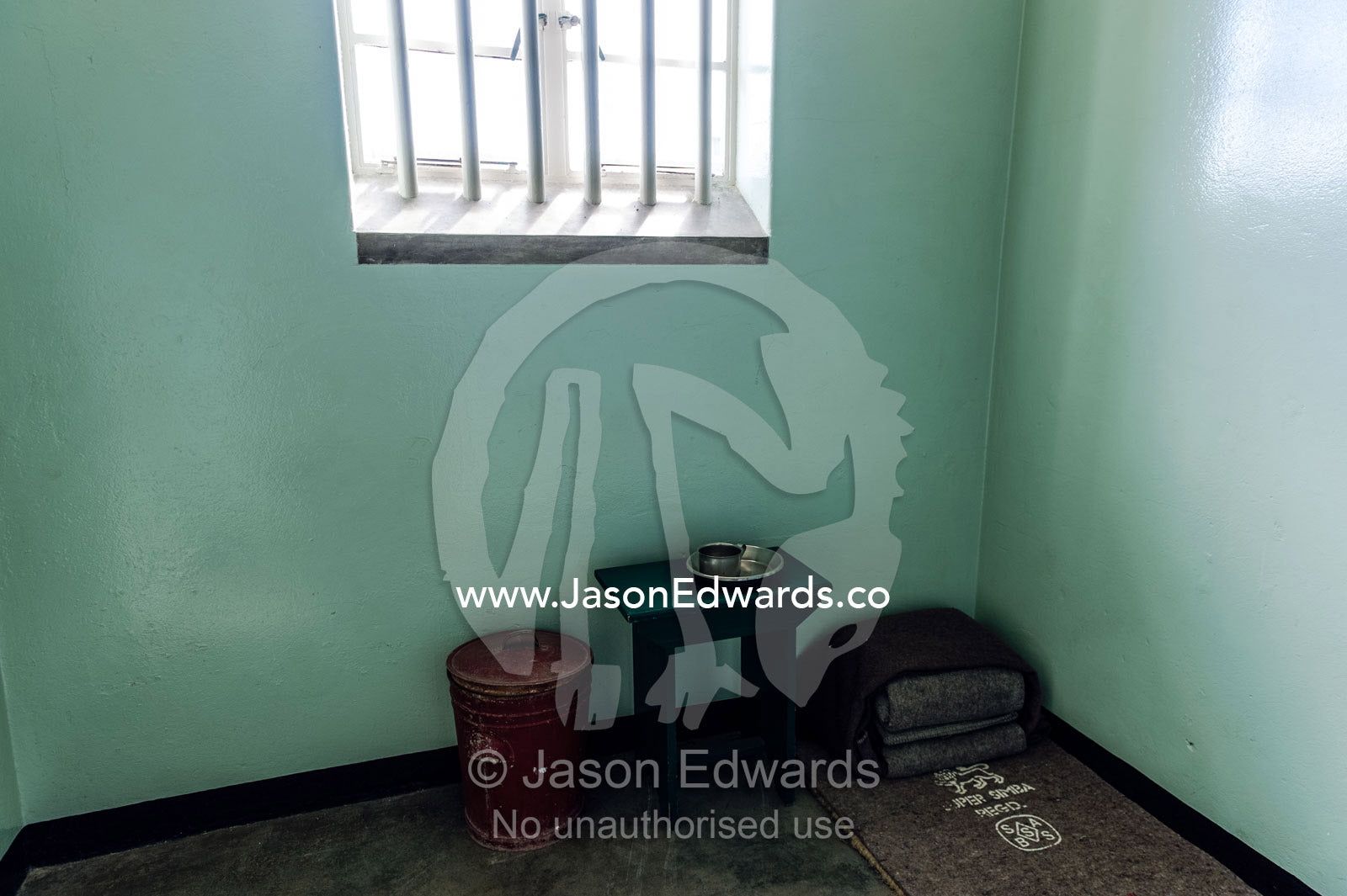 A cup, bowl and bed roll in the cell inhabited by Nelson Mandela. Robben Island, Cape Town, Bloubergstrand, Table Bay, Western Cape, South Africa.