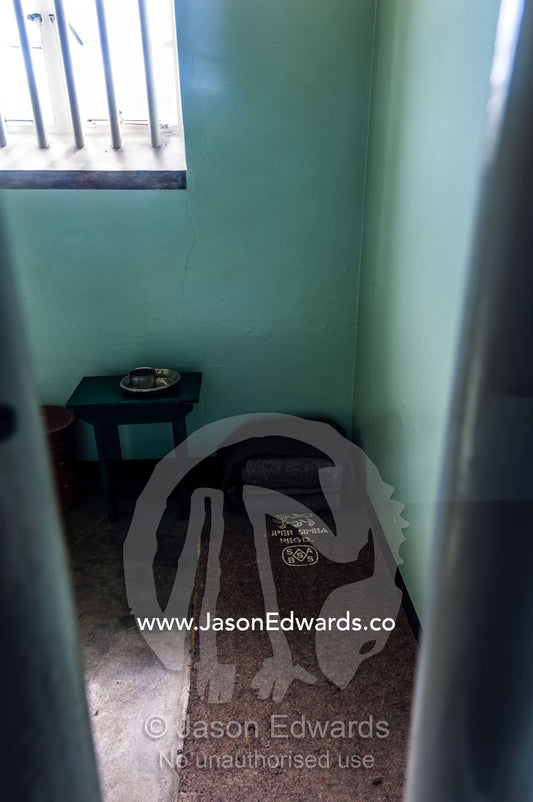 A cup, bowl and bed roll in the cell inhabited by Nelson Mandela. Robben Island, Cape Town, Bloubergstrand, Table Bay, Western Cape, South Africa.