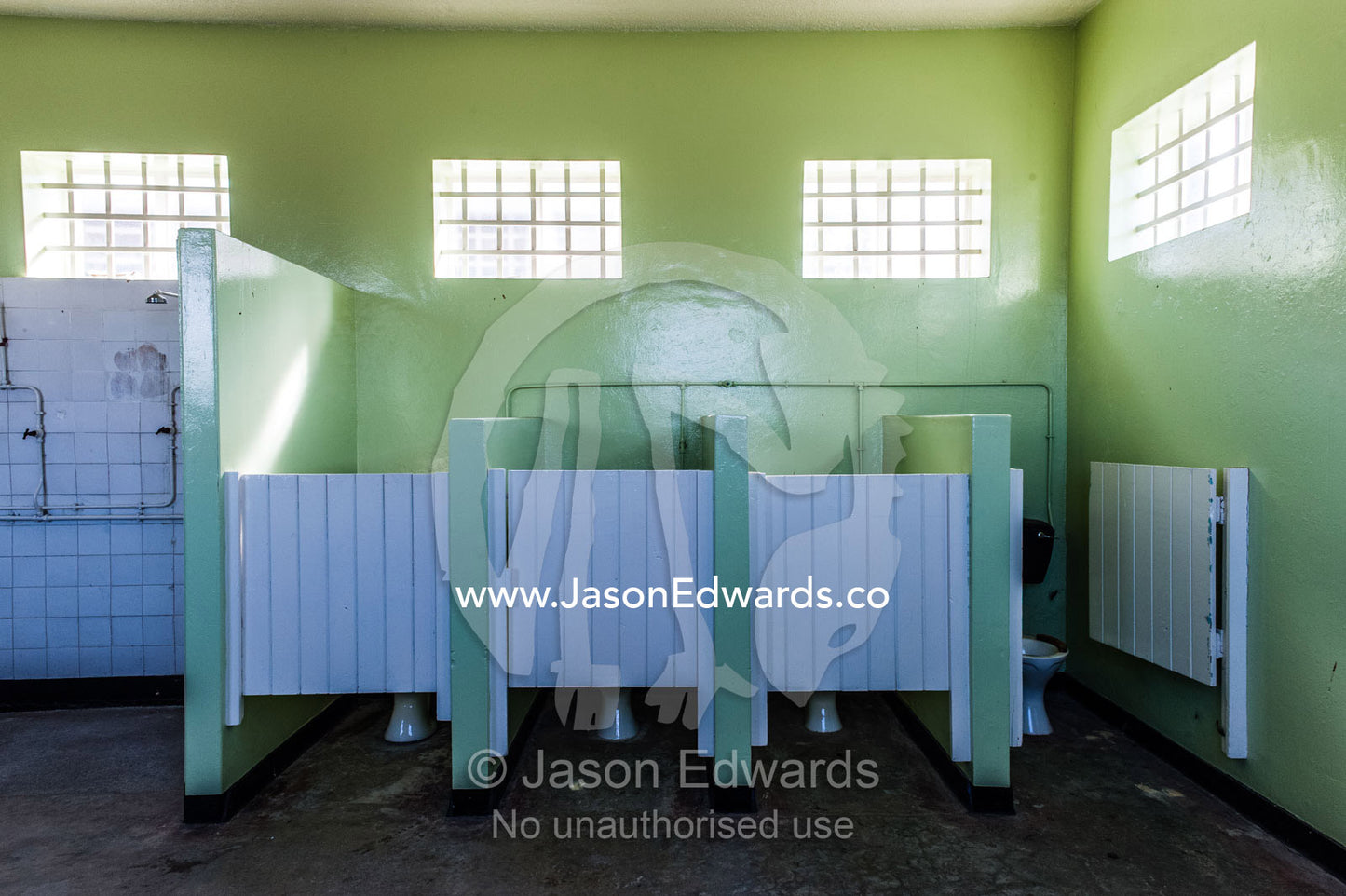 Male toilet cubicles in a prison bathroom on Robben Island. Robben Island, Cape Town, Bloubergstrand, Table Bay, Western Cape, South Africa.