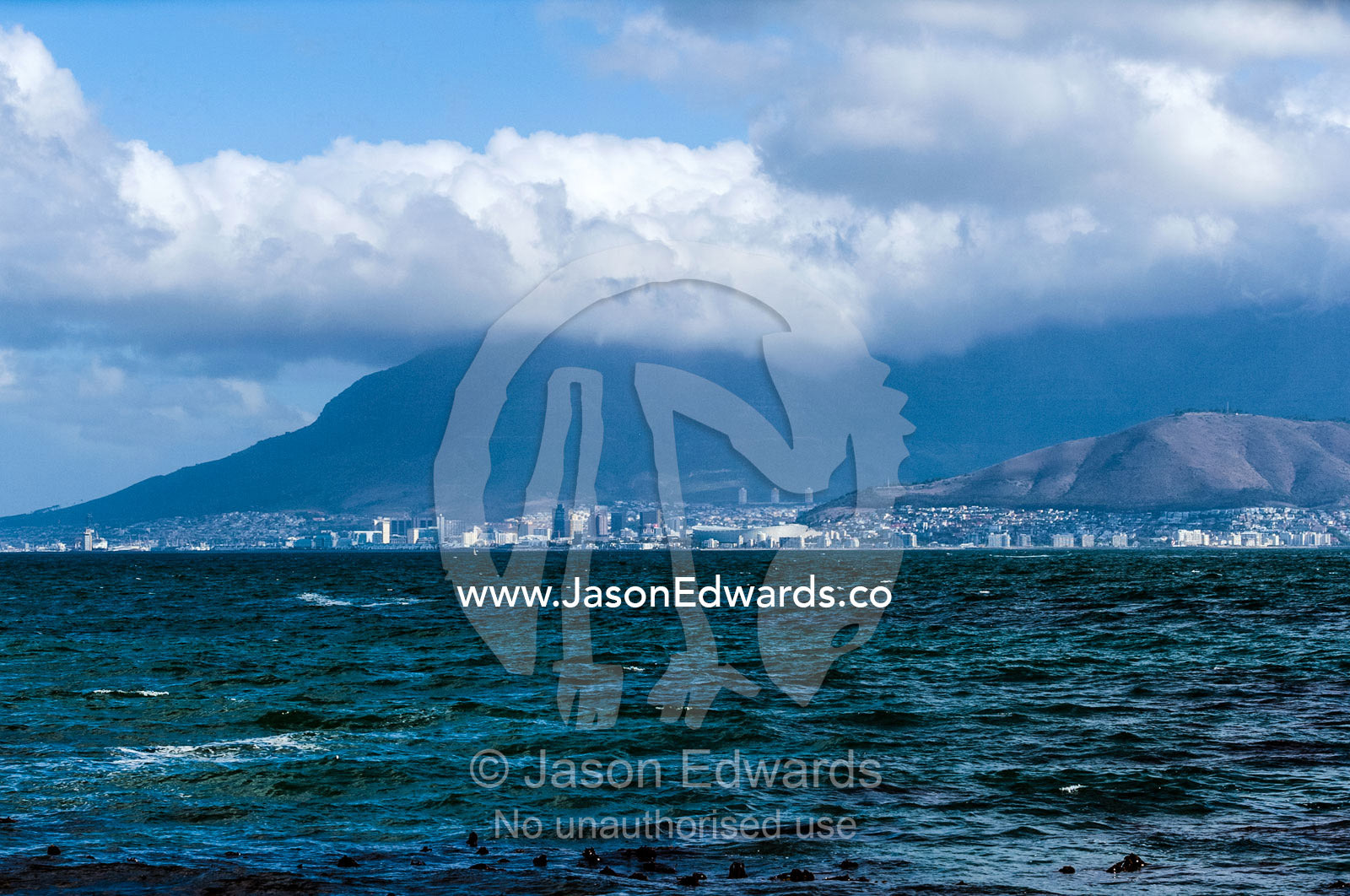 The city and suburbs of Cape Town across the Table Bay sea channel. Robben Island, Cape Town, Bloubergstrand, Table Bay, Western Cape, South Africa.
