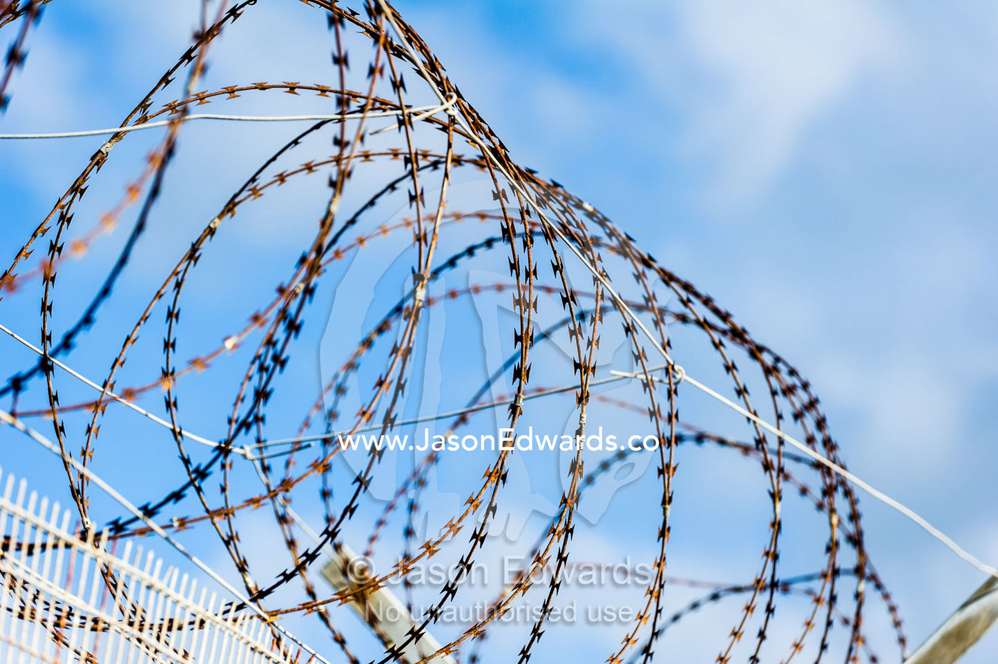 A steel and wire mesh fence topped with razor wire surrounds a prison. Robben Island, Cape Town, Bloubergstrand, Table Bay, Western Cape, South Africa.