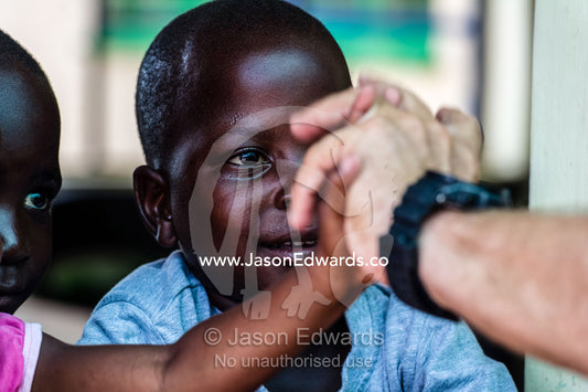 Children play with a tourist through a classroom window in a school. Kruger National Park, Manyeleti, Shalati Village, Mnisi Community, Limpopo, South Africa.