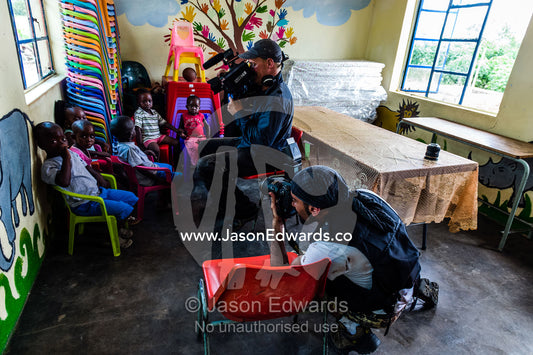 A film crew photographs children in a small African Primary school. Kruger National Park, Manyeleti, Shalati Village, Mnisi Community, Limpopo, South Africa.