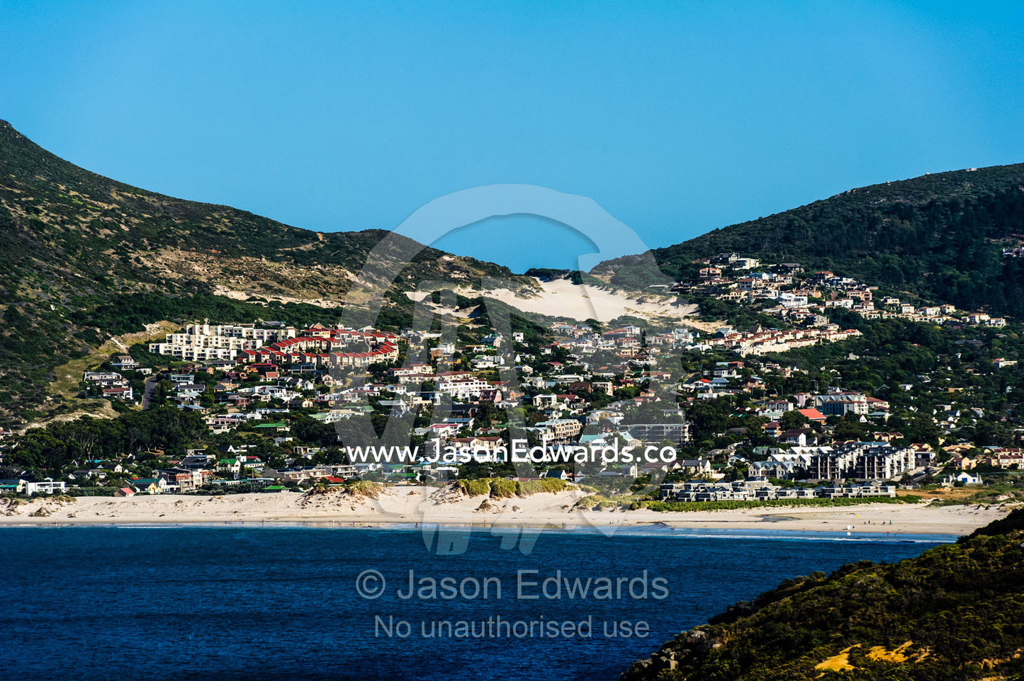 A coastal community in a sheltered bay surrounded by sand dunes. Hout Bay, Cape Town, Chapmans Peak Drive, Western Cape, Cape Peninsula, South Africa.