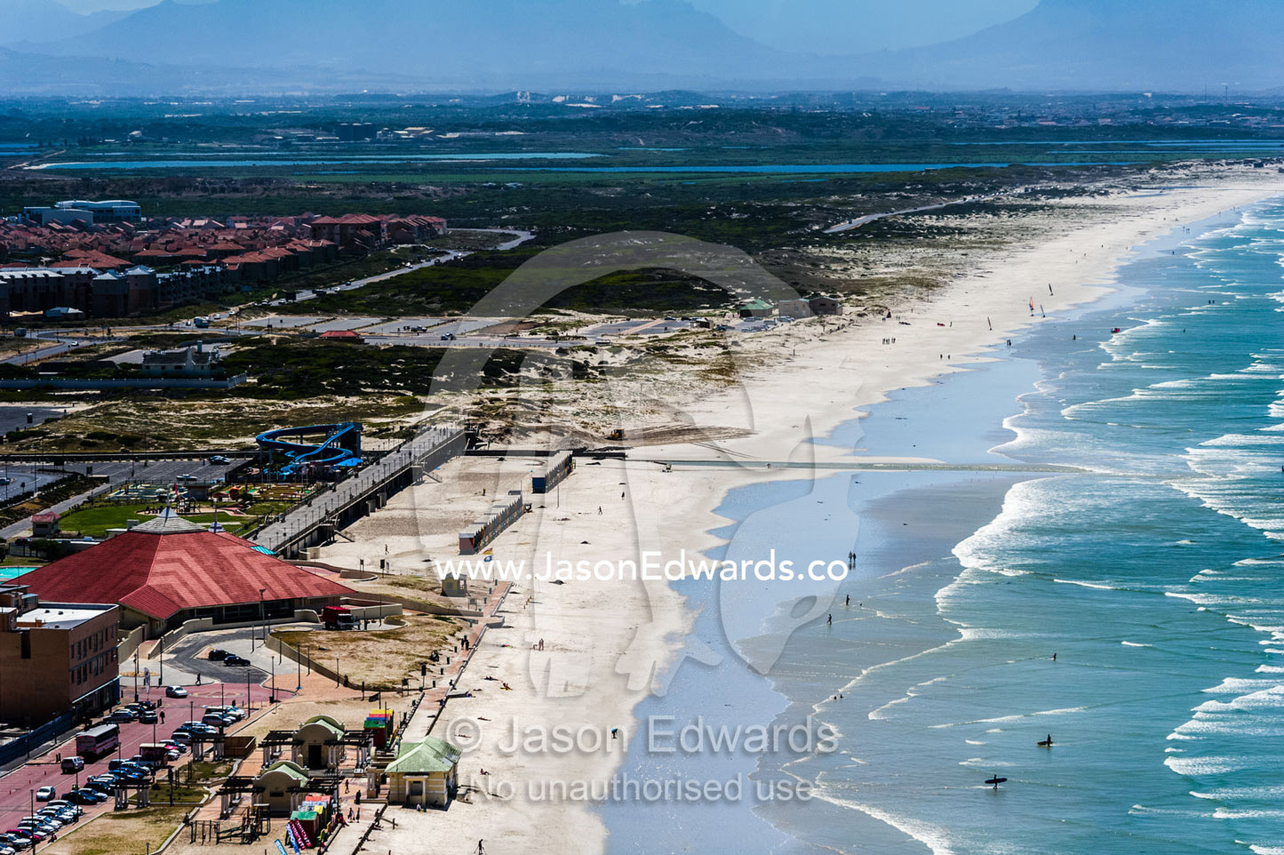Beachside resorts, bathing boxes, waterpark and apartments by the sea. Surfers Corner, Muizenberg, Cape Town, Chapmans Peak Drive, Western Cape, South Africa.