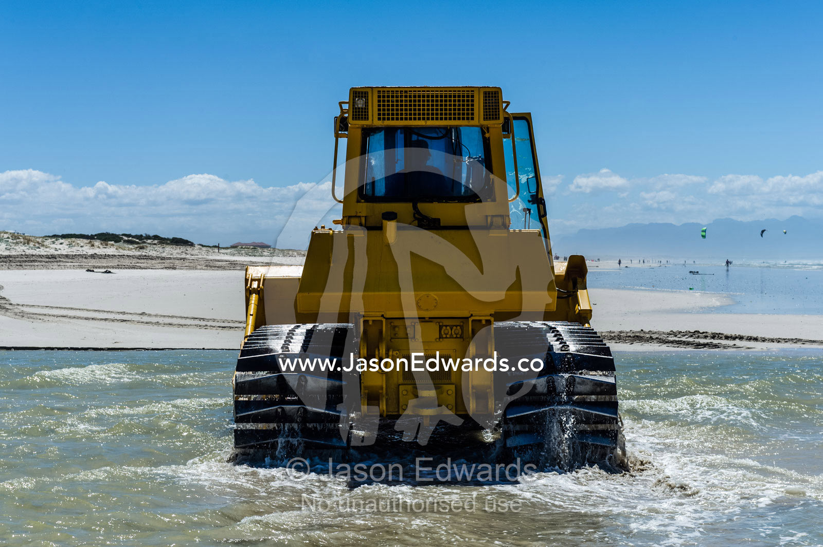 Bulldozers move beach sand to prevent sand dune erosion by the ocean. Surfers Corner, Muizenberg, Cape Town, Chapmans Peak Drive, Western Cape, South Africa.