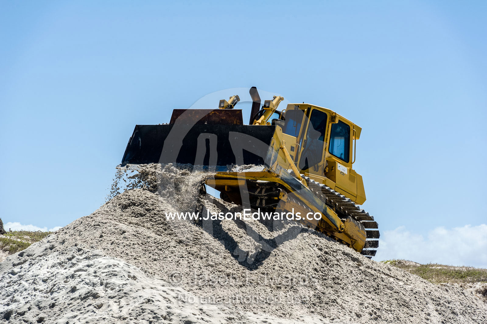 Bulldozers move beach sand to prevent sand dune erosion by the ocean. Surfers Corner, Muizenberg, Cape Town, Chapmans Peak Drive, Western Cape, South Africa.