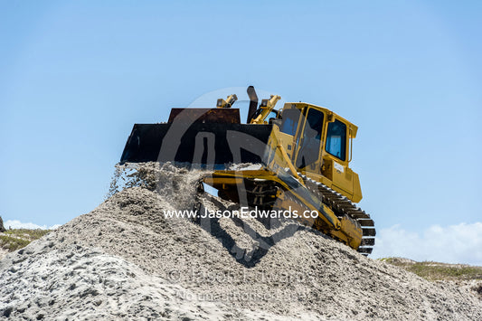 Bulldozers move beach sand to prevent sand dune erosion by the ocean. Surfers Corner, Muizenberg, Cape Town, Chapmans Peak Drive, Western Cape, South Africa.
