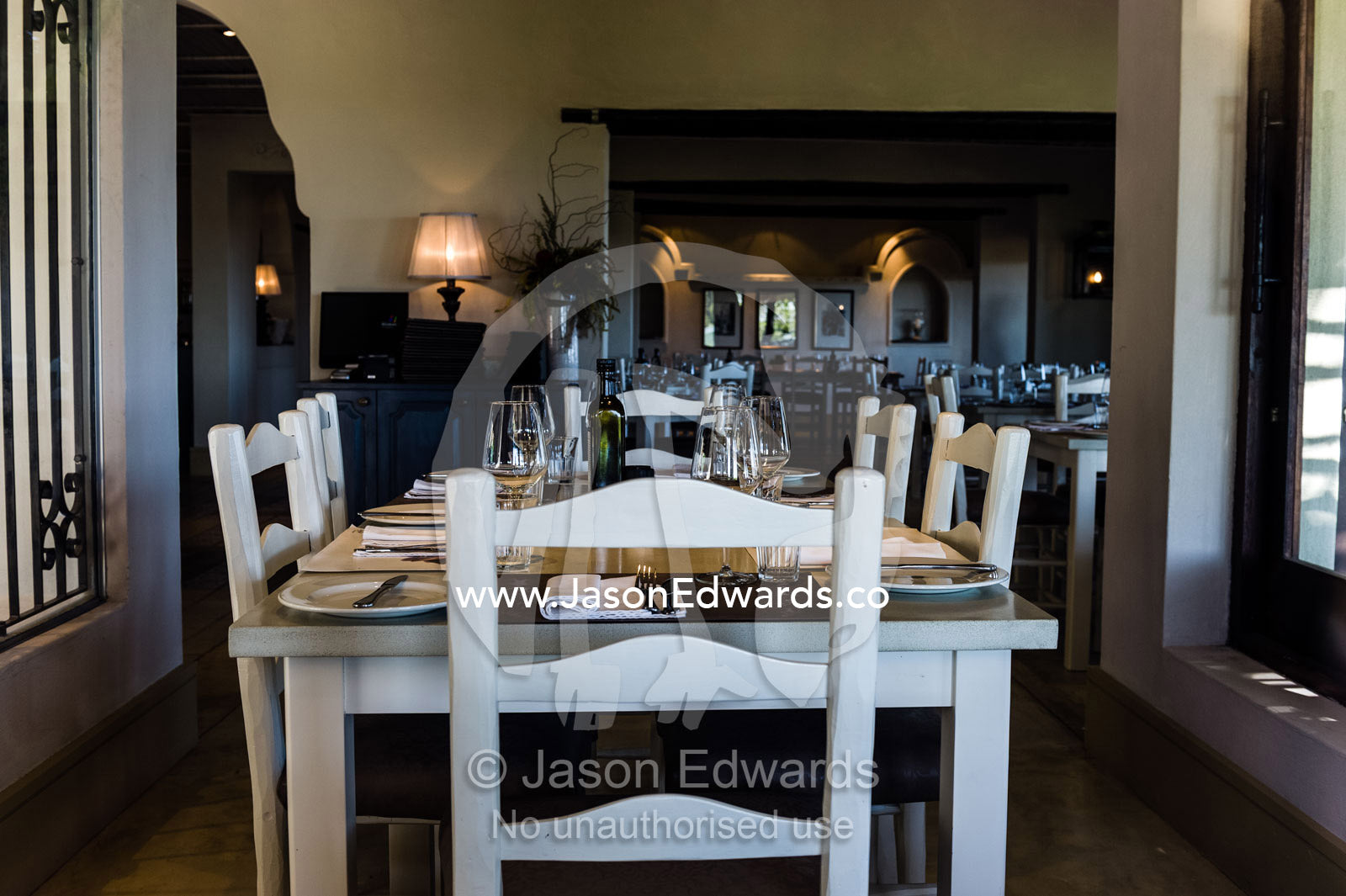 An elegant dining table set for a meal in a vineyard restaurant. Spice Route Winery, Stellenbosch, Western Cape, South Africa.