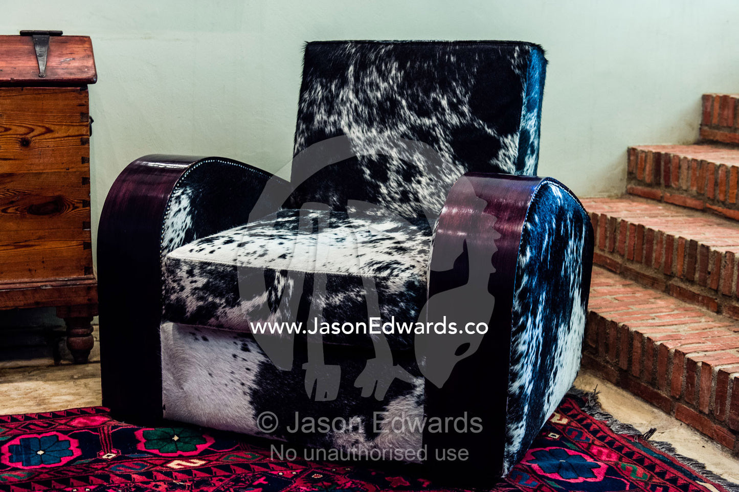 An inviting elegant Nguni Skin Chair in a winery guest lounge. Fairview Wine Estate, Stellenbosch, Western Cape, South Africa.