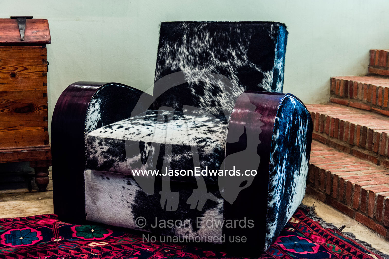 An inviting elegant Nguni Skin Chair in a winery guest lounge. Fairview Wine Estate, Stellenbosch, Western Cape, South Africa.
